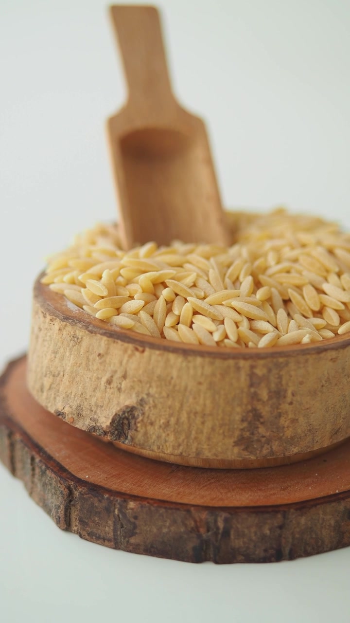 Pasta orzo cruda in una ciotola di legno rustica