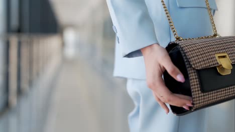 close-up of a women's handbag on a girl in a blue suit