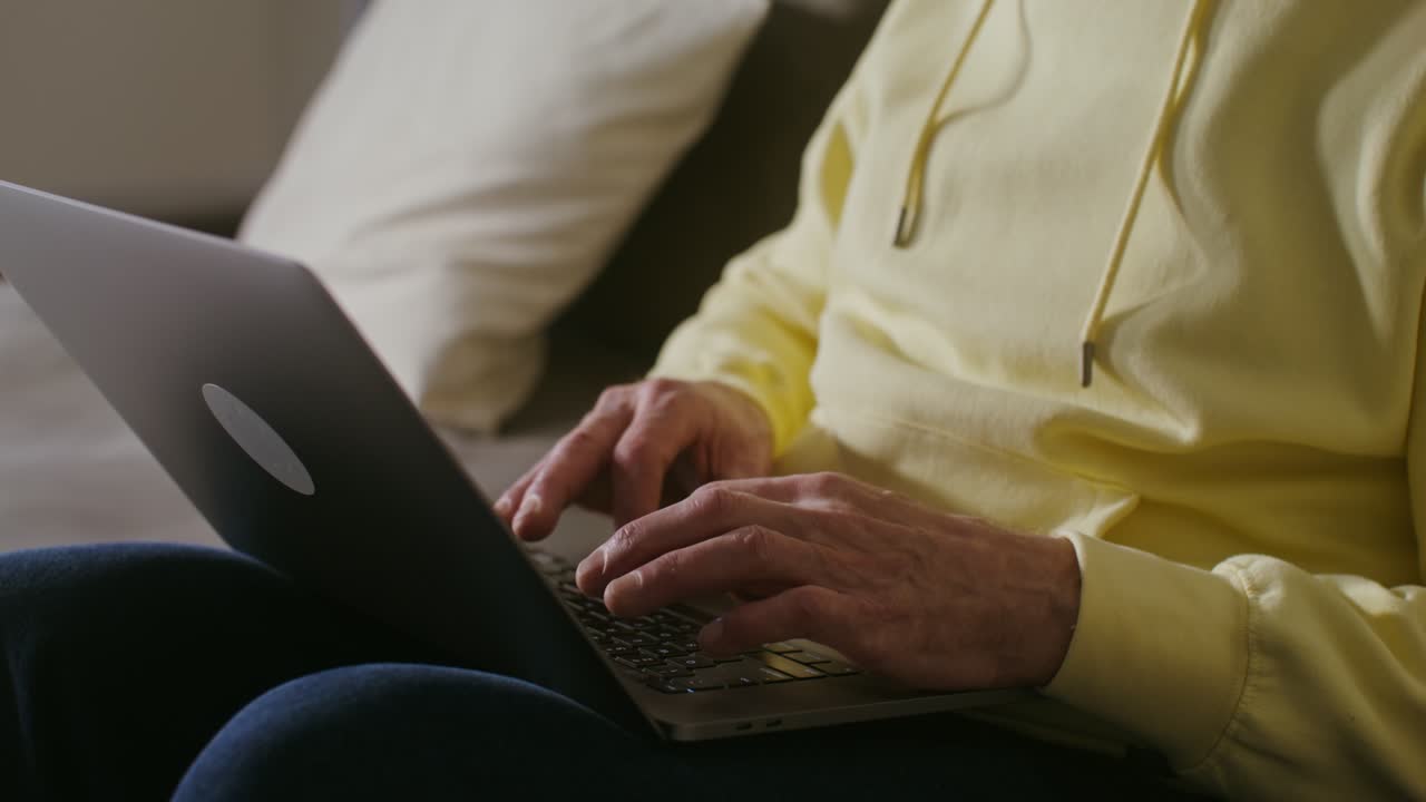 Senior Man Using Laptop on a Couch