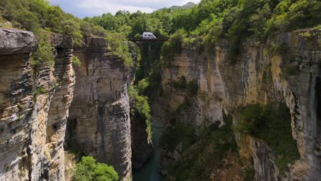 Vista-Aérea:-Río-Sereno,-Acantilados-Rocosos,-Exuberante-Vegetación,-Puente-Del-Río-Osum-En-Albania