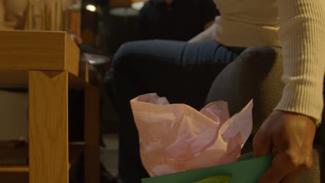 multi-cultural friends giving man birthday present at home with cake and candles at party