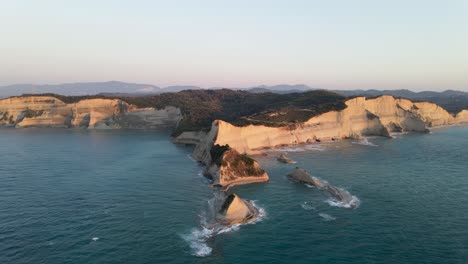 Aerial-heading-slow-towards-Cape-Drastis-at-golden-hour,-Corfu,-Greece