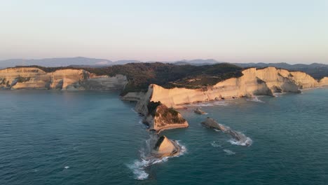 aerial heading slow towards cape drastis at golden hour, corfu, greece