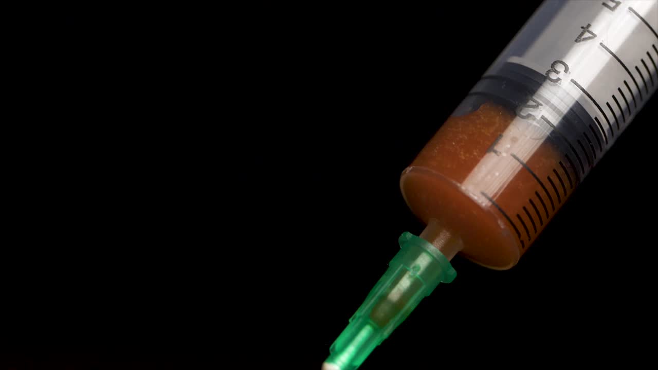 jeringuilla con líquido naranja