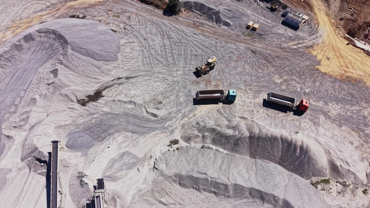 Construction site with heavy machinery working on gravel and sand