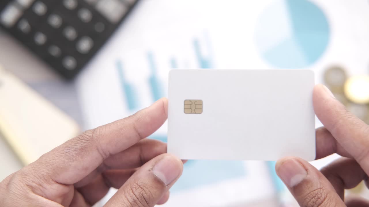 manos con una tarjeta de crédito con documentos financieros