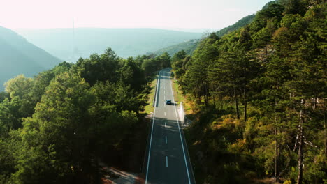 blue car passing through mountain road in rural countryside