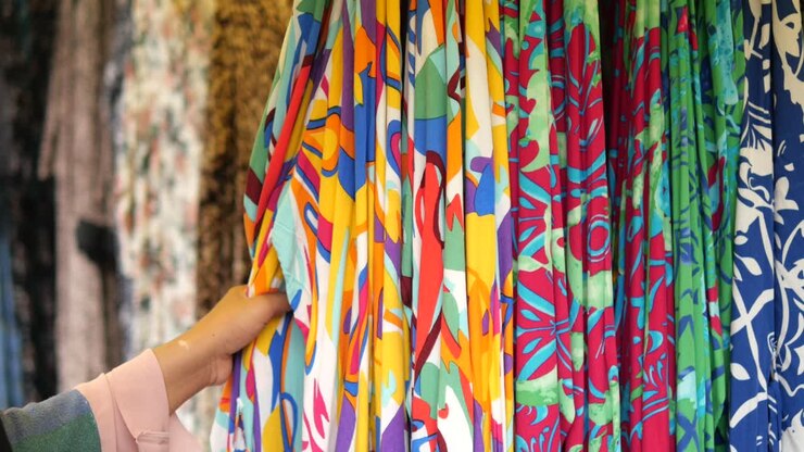 Woman browsing colorful fabric display in store