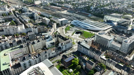 Backwards-drone-tilt-shot-of-the-new-Rennes-station-between-high-rise-buildings