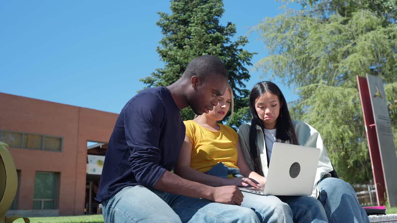 Group of students working on a laptop on campus