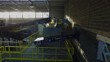 aerial view inside modern recycling factory with conveyor belt sorting trash in background