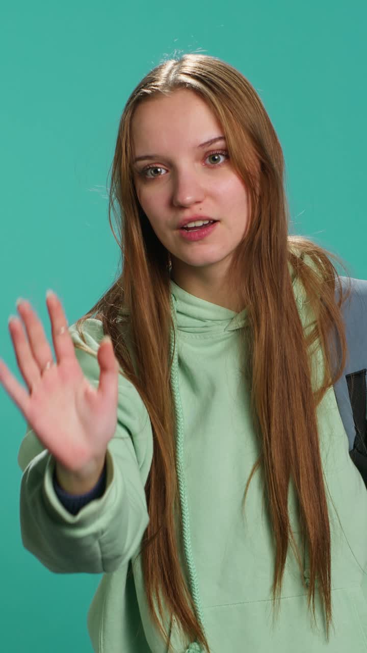 Vertical video Assertive young woman doing stop hand gesture