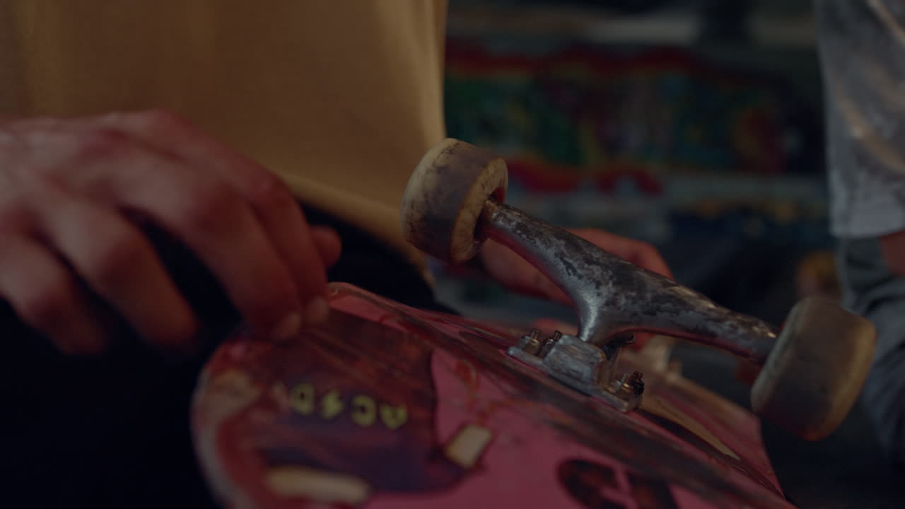 skateboarder sosteniendo la tabla de patinaje en las manos en la ciudad. manos del hombre tocando la tabla.