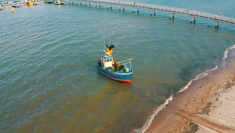 vista aérea de un barco de pesca que comienza lentamente a ir hacia el mar