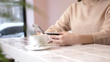 beautiful woman online banking using smartphone shopping online with credit card at home lifestyle. technology and internet concept - smiling woman sitting with smartphone and credit card 60 fps