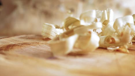 Planed-wood-shavings-being-dropped-onto-a-wood-stump-in-slow-motion-using-a-Macro-lens