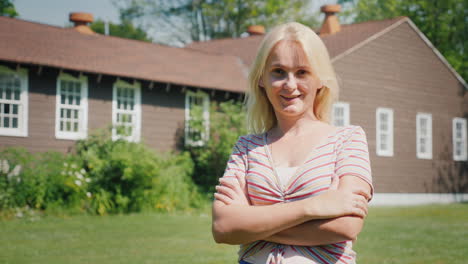 portrait of a caucasian woman on the background of a new country house buying a property