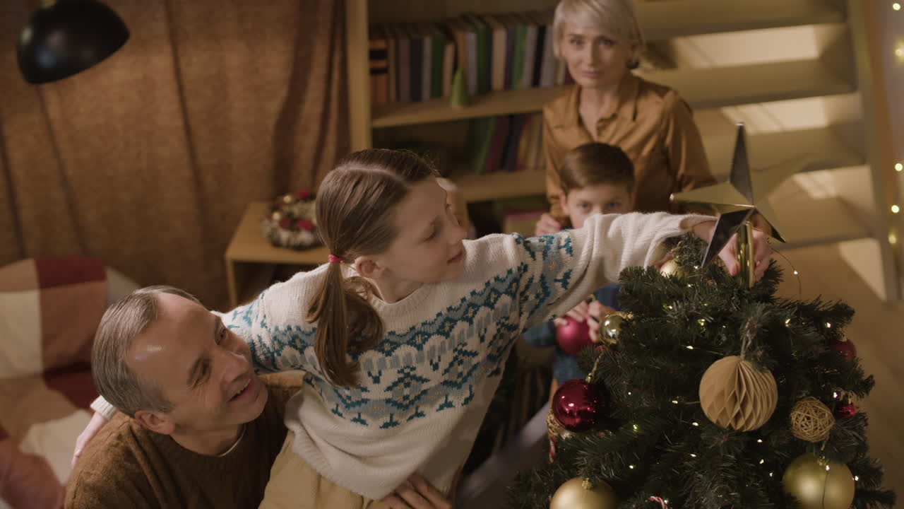 familia decorando el árbol de navidad juntos