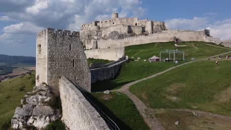 old castle ruin on a grassy green hill with tall walls and defense systems