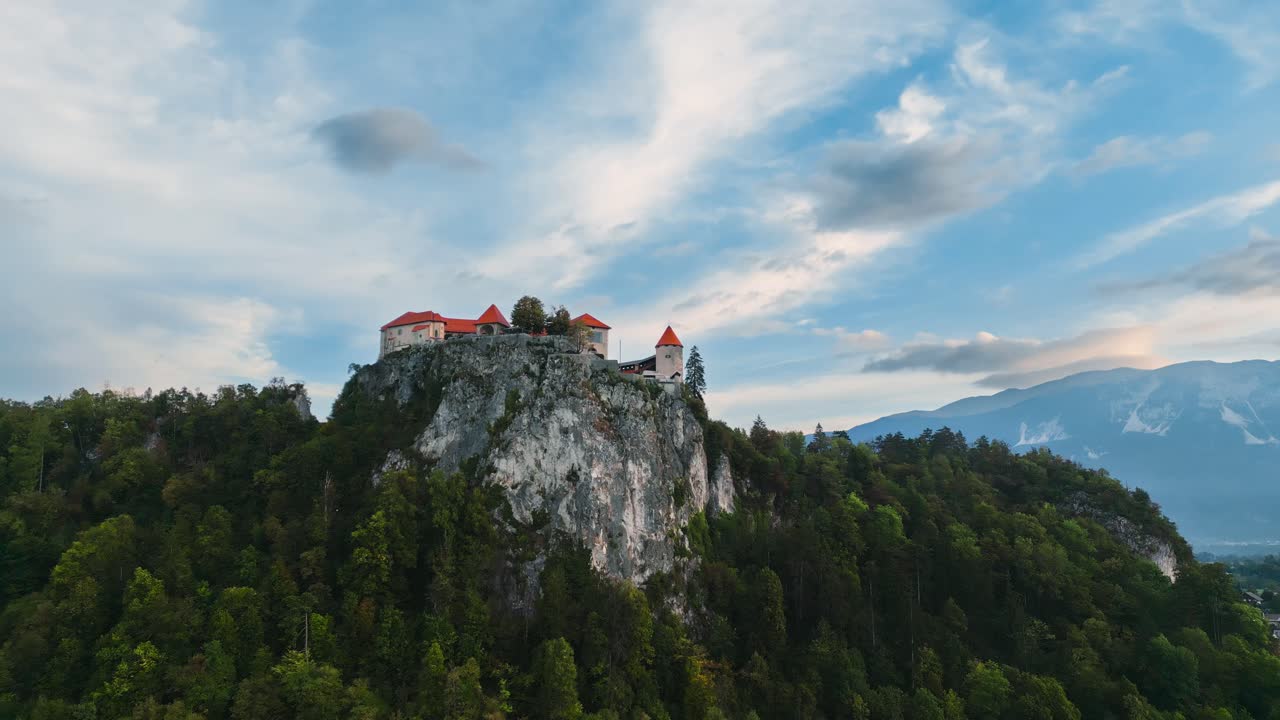 fortaleza del castillo en un acantilado rocoso empinado, eslovenia sangrada, interesante ubicación de viaje histórico, tiro aéreo de drones de ángulo bajo, cine épico 4k