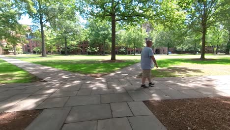 4k hombre caminando en el campus de izquierda a derecha