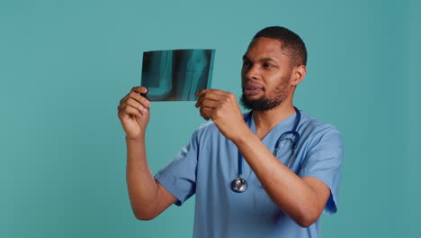 male nurse analyzing radiology x ray scan to provide patient with diagnosis