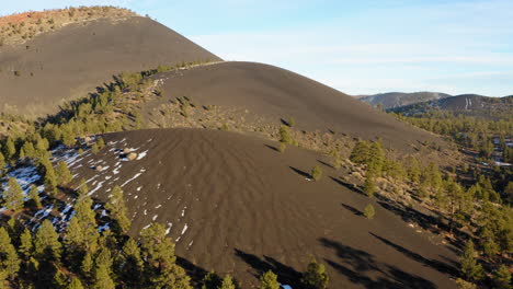 drone flying over sunset crater volcano at national monument, arizona showing cinder cone volcanic mountain