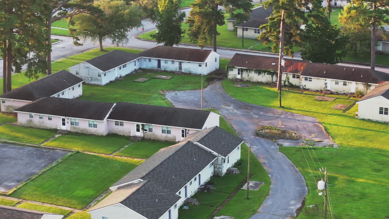 Cinematic drone shot of abandoned apartments with vegetation growing on the buildings, static aerial footage