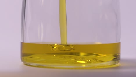 slow motion extreme close up food oil pouring in jar