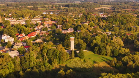 aizpute water tower (observation tower); 4k aerial establishing buildings and location.