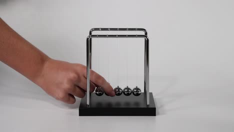 la mano inicia el movimiento en la cuna de newton.