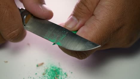 Footage-of-hands-slowly-sharpening-a-pencil-and-some-coloured-pencils-with-a-sharp-knife