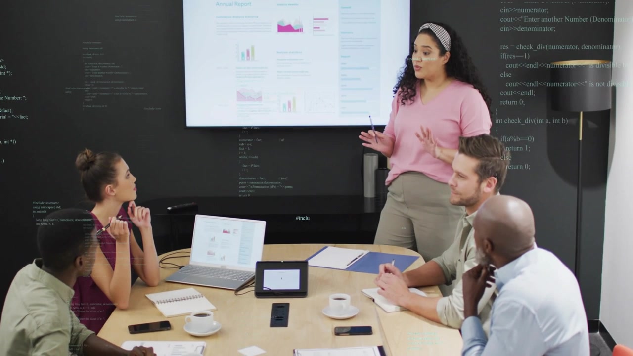Presenter pointing pen at screen, activating animated charts while team taking notes for business