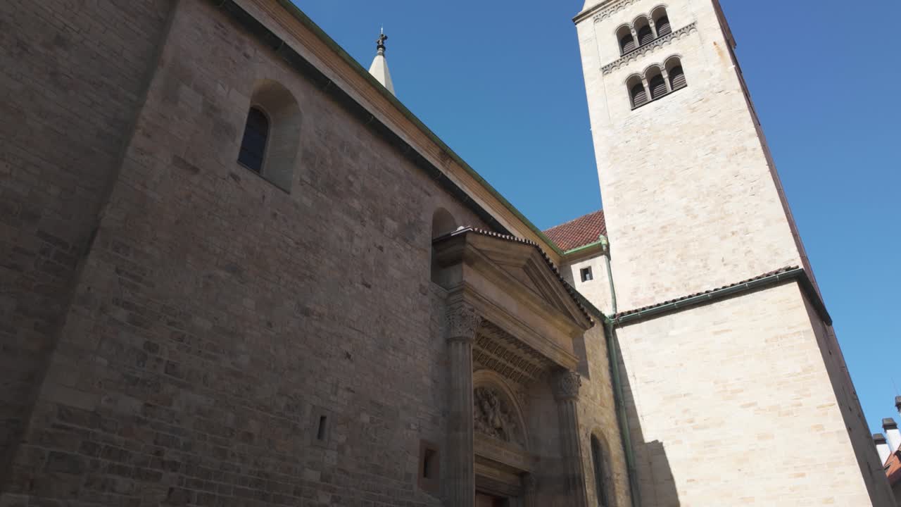 The exterior of St. George's Basilica in Prague on a bright sunny day, showing stone walls and entrance