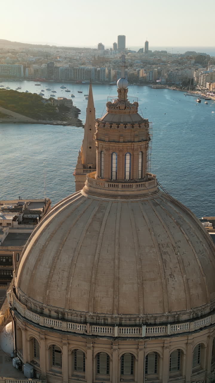 Aerial drone view of the walled city of Valletta, Malta, surrounded by the Mediterranean sea in daylight. Vertical vertical
