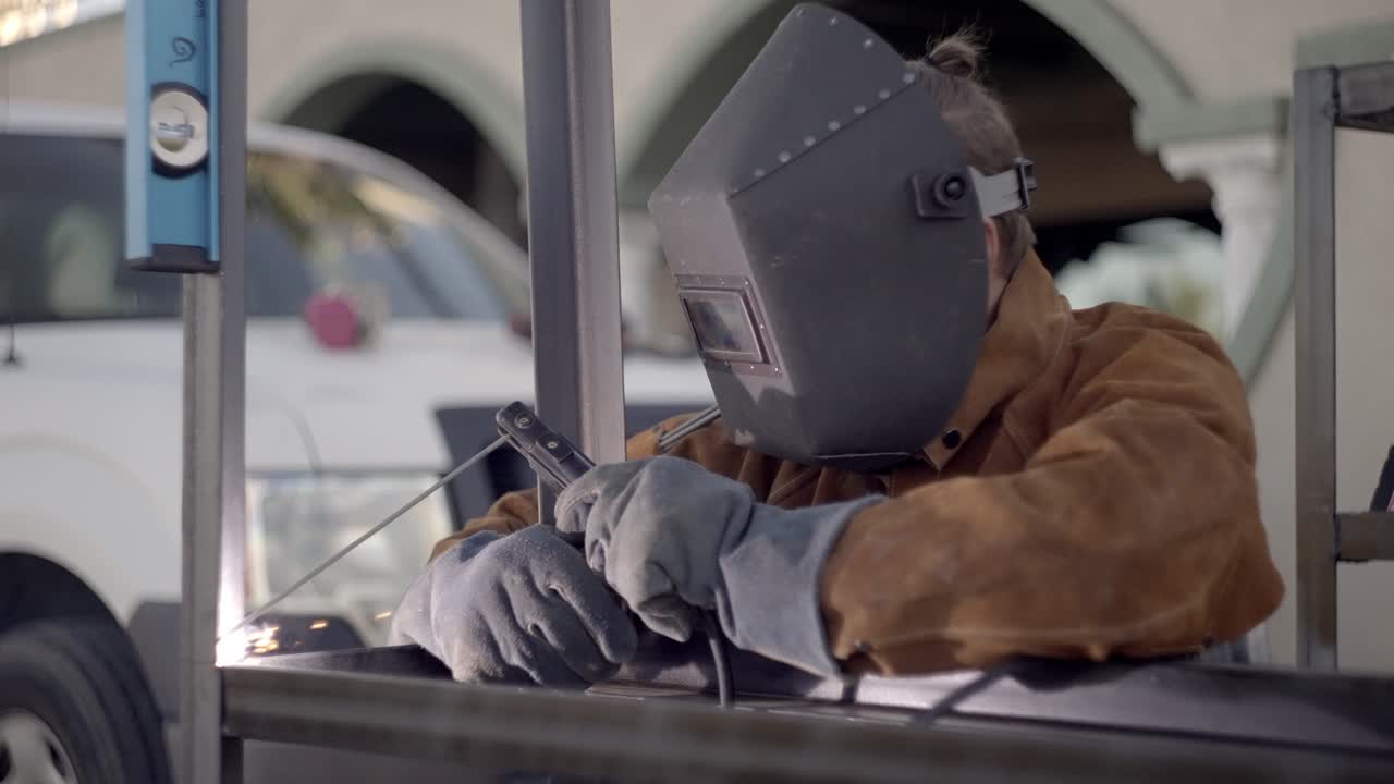 soldador profesional está soldando marco de metal para proyecto de construcción