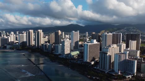 toma de drones cinematográficos de 4k en el sentido de las agujas del reloj de la playa de waikiki y los hoteles detrás de ella durante el amanecer en oahu