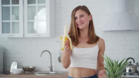 Young woman in the kitchen. Portrait of young sporty woman eating healthy food
