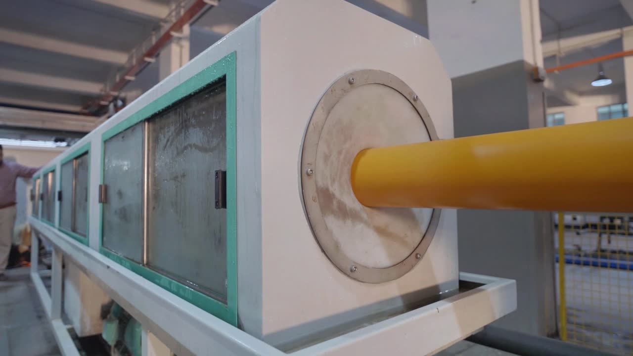 Pipe inserted at a machine for production of PVC Pipe in an industry at Karachi, Pakistan.