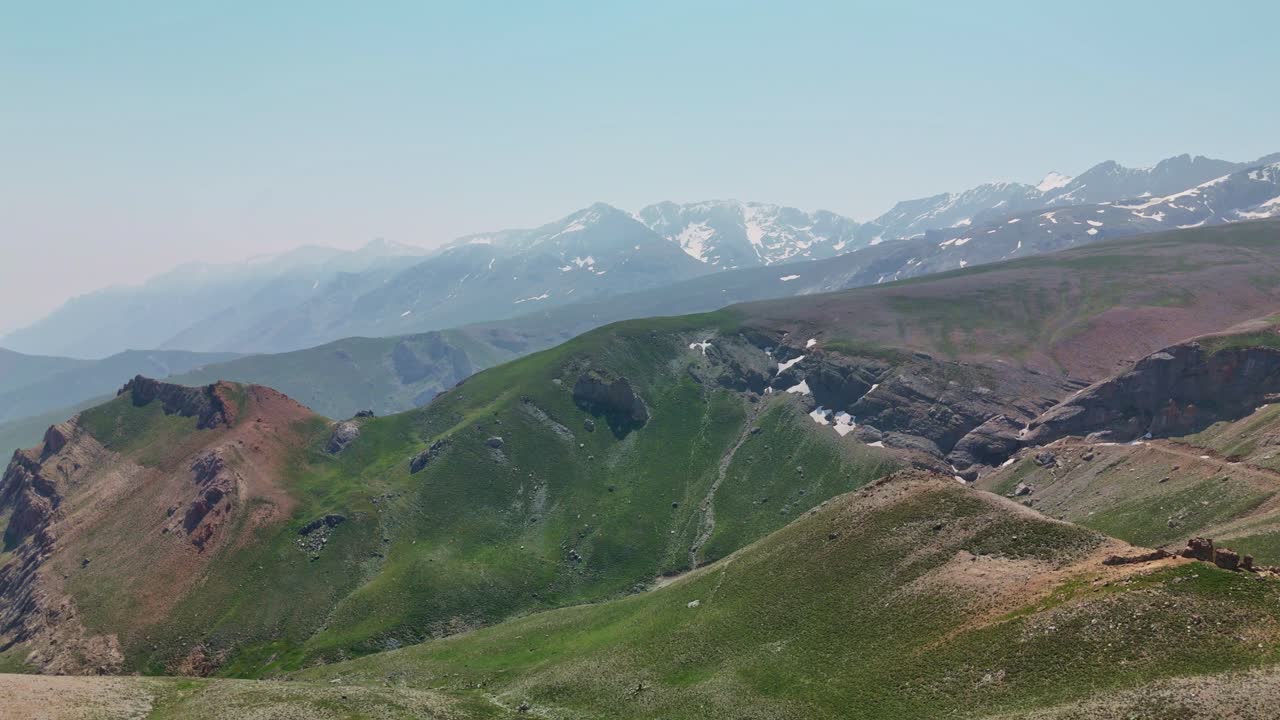 Drone view snowy mountain peaks in sunny weather, serene and expansive