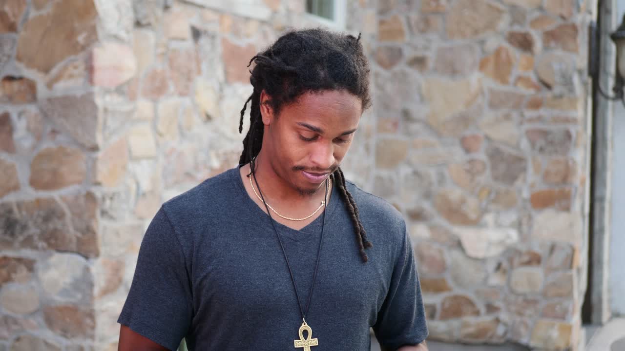 카메라가 주위를 맴돌면서 전화기에 험상을 가진 아프리카계 미국인 남자