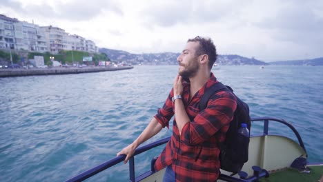 Happy-man-talking-on-the-phone-on-the-ferry.