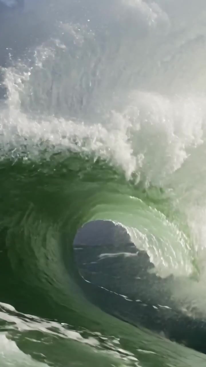 Vertical video: Rising green wave hitting bow in stormy sea with worn paint rust spray, copy space