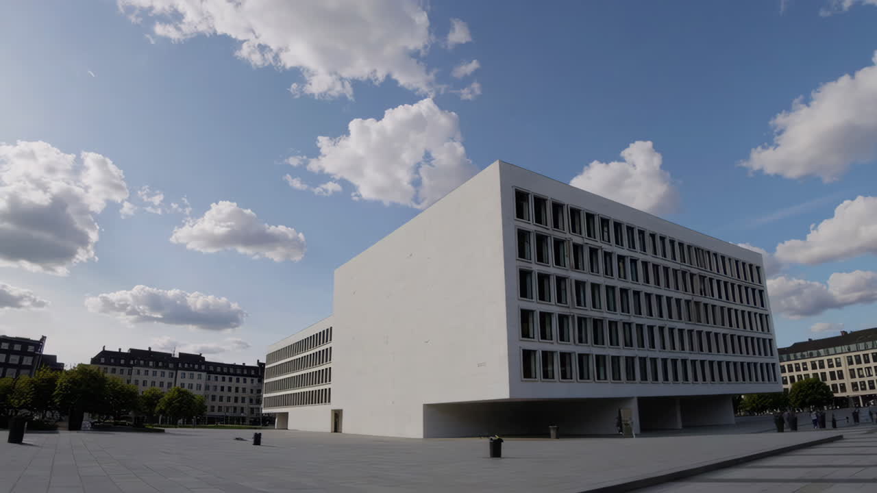 Modern White Building in an Urban Plaza Under a Cloudy Sky