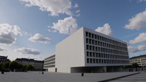 modern white building in an urban plaza under a cloudy sky