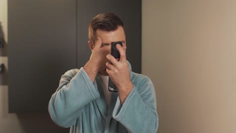 Close-up-portrait-of-a-handsome-man-applying-hairspray-to-his-hair