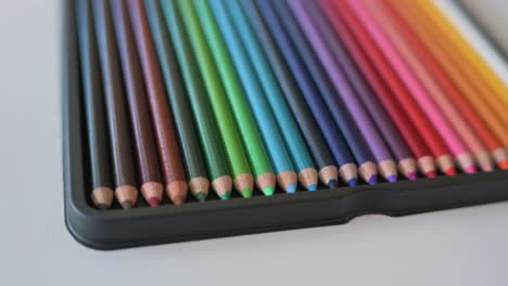 closeup of color pencils arranged in a rainbow pattern slowly rotating from angle