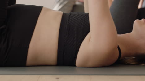 yoga class healthy pregnant woman practicing stretches laying on exercise mat enjoying group physical fitness workout in studio