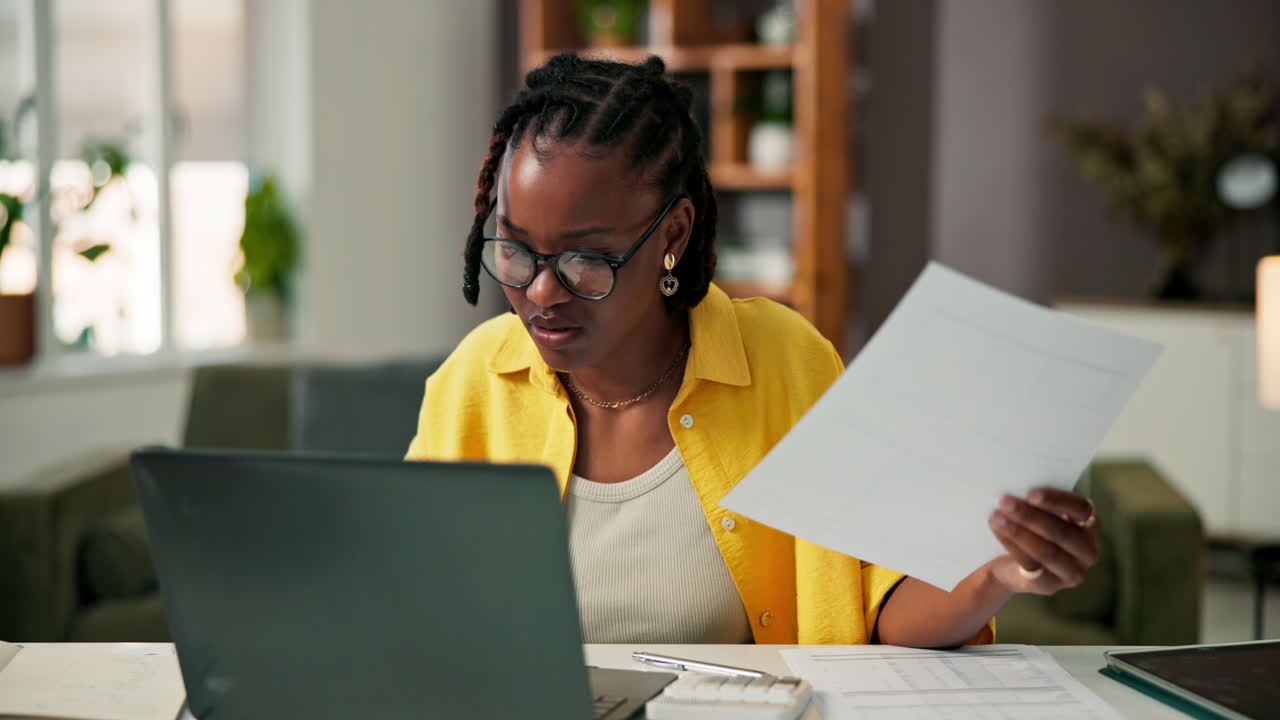 Woman working from home with laptop and documents