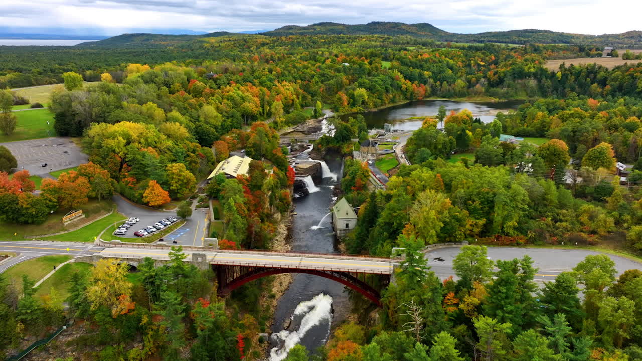 Approaching the stunning nature in Champlain Lake near Vermont, New England, USA. Beautiful woods change the foliage color in autumn. Aerial view.